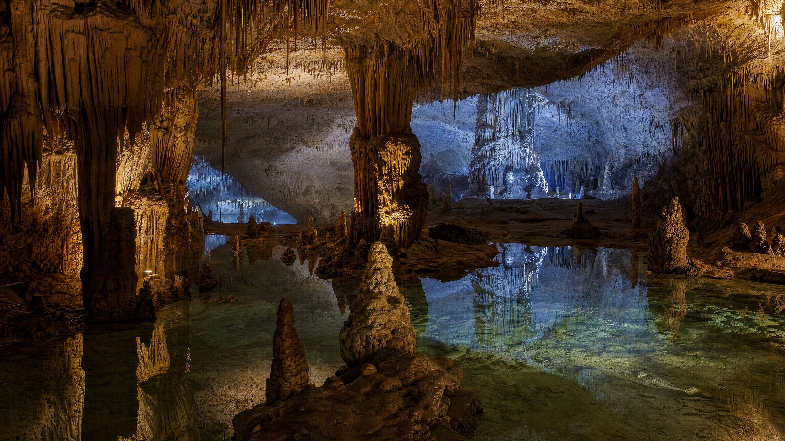 Intérieur de la Grotte de Han avec stalactites, stalagmites et rivière souterraine illuminée