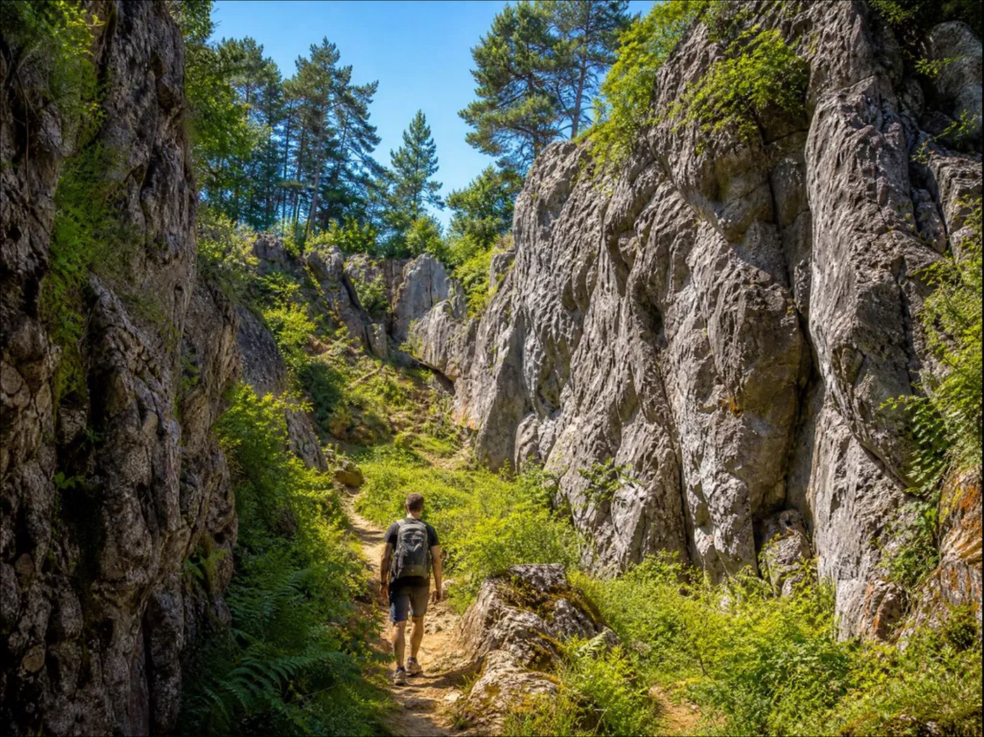Randonneur progressant dans un couloir rocheux du Fondry des Chiens